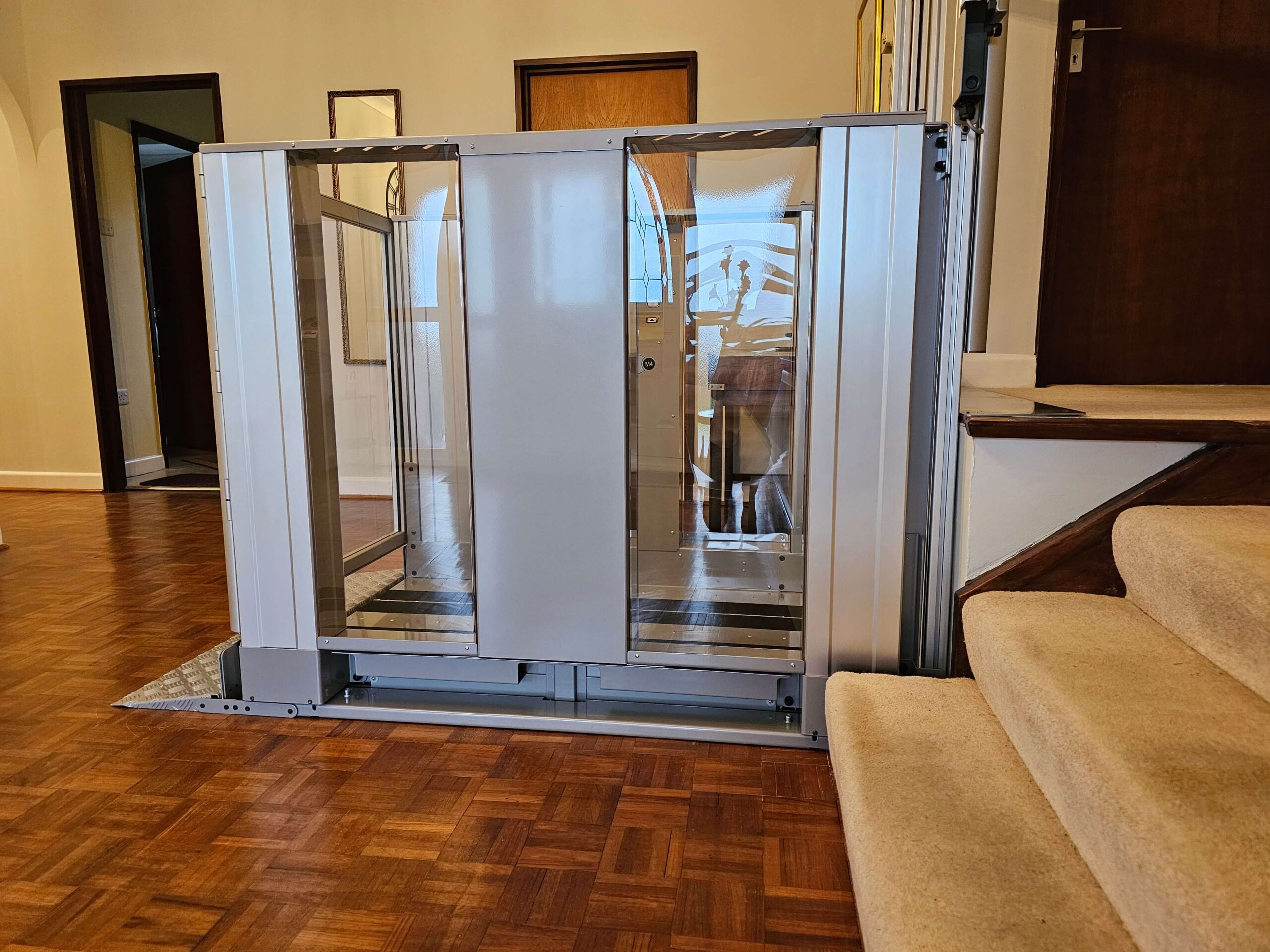 Platform lift in a hallway next to steps