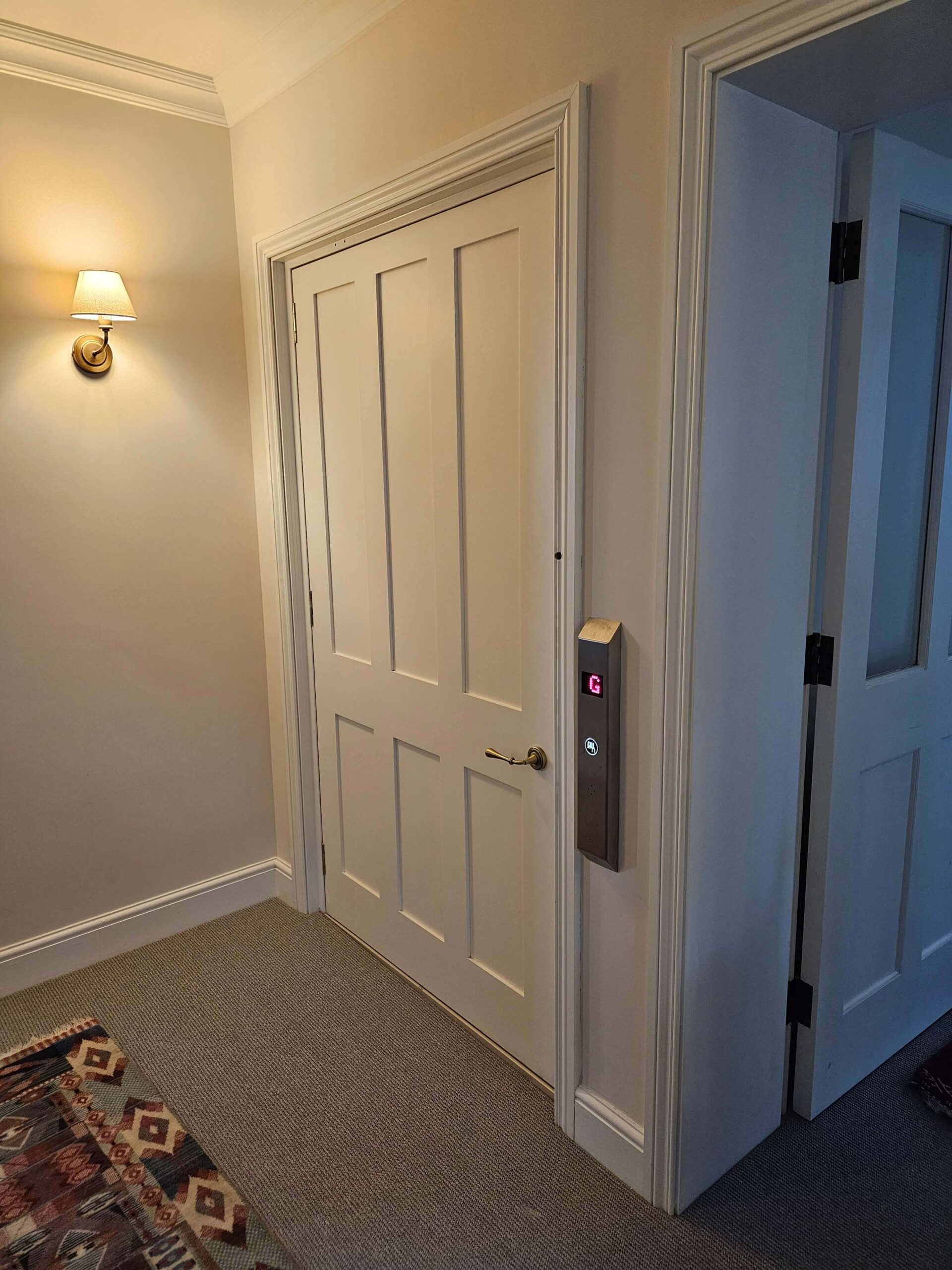 British Style lift doors closed, the bespoke timber door blending with the existing internal doors.