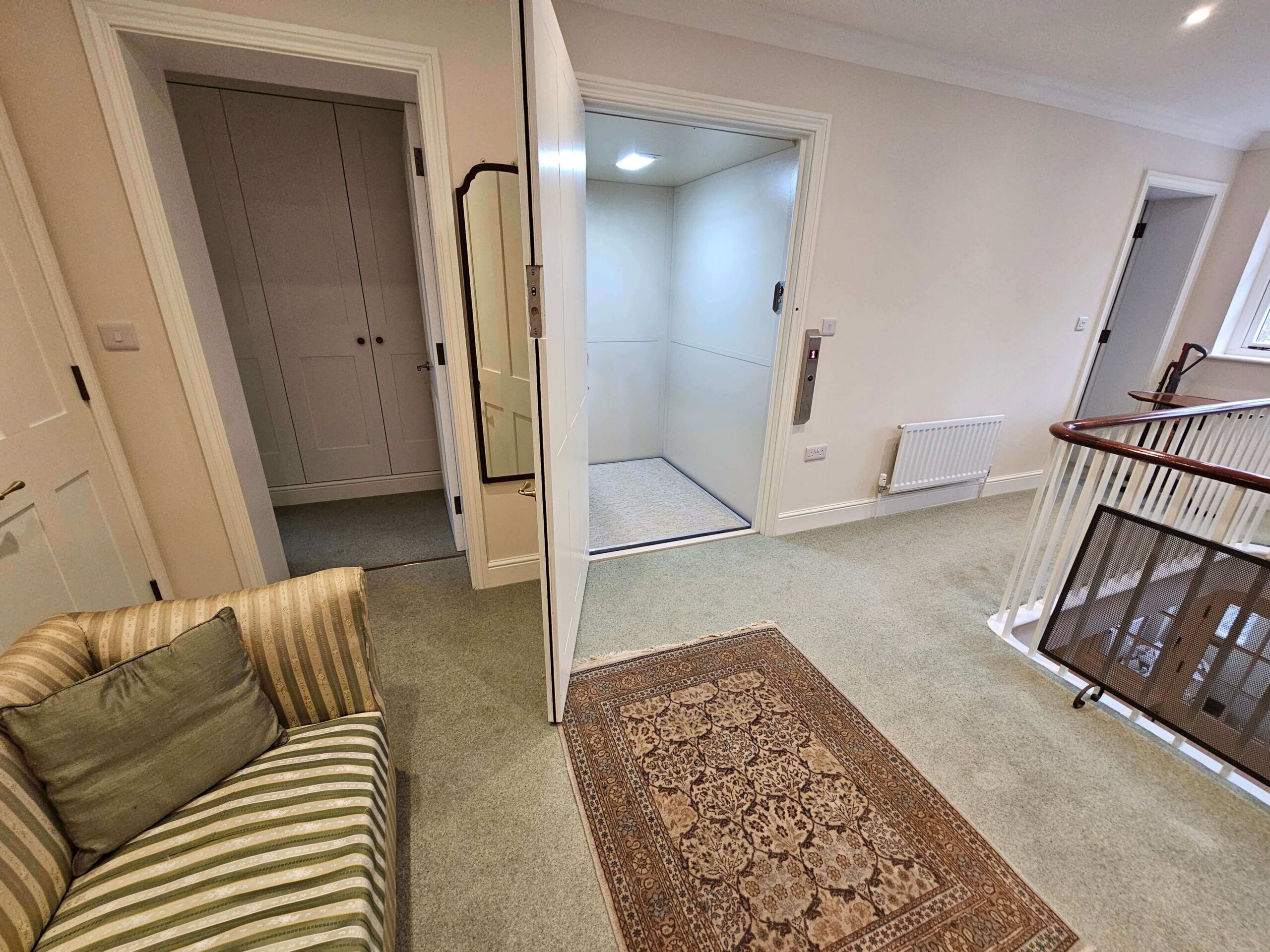 First floor landing with the British Style vertical platform lift doors open, showing the bespoke interior.