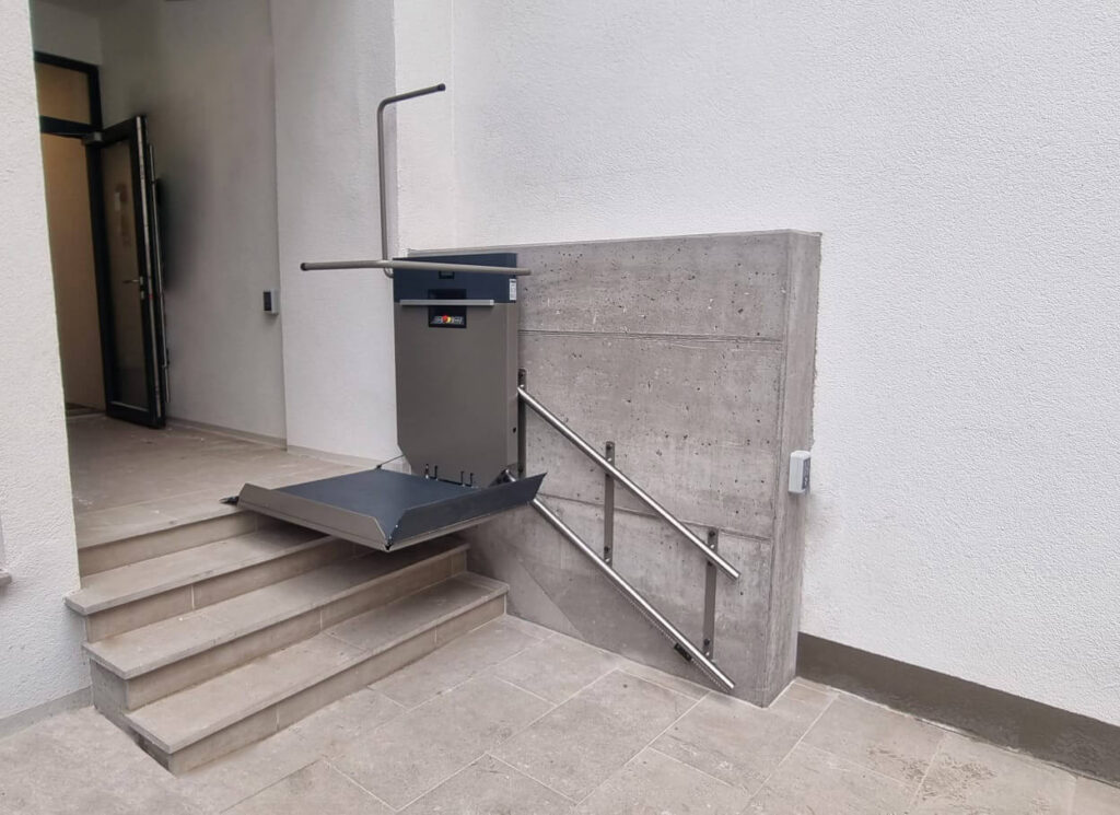 Platform stair lift going up a flight of steps in a building