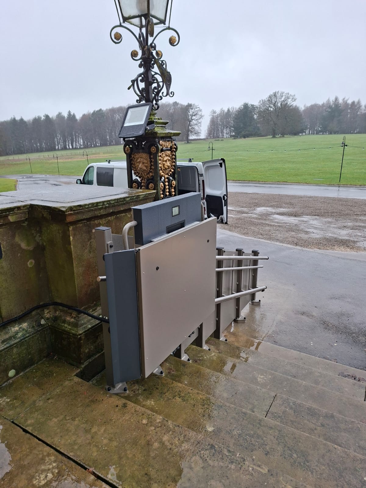 GTLE inclined stairlift in stowed position on the external steps at Harewood House, showing compact footprint.