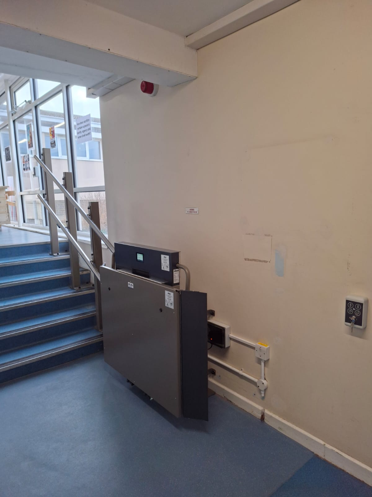 GTLE platform stair lift in stowed position at base of Filey Academy main corridor steps.