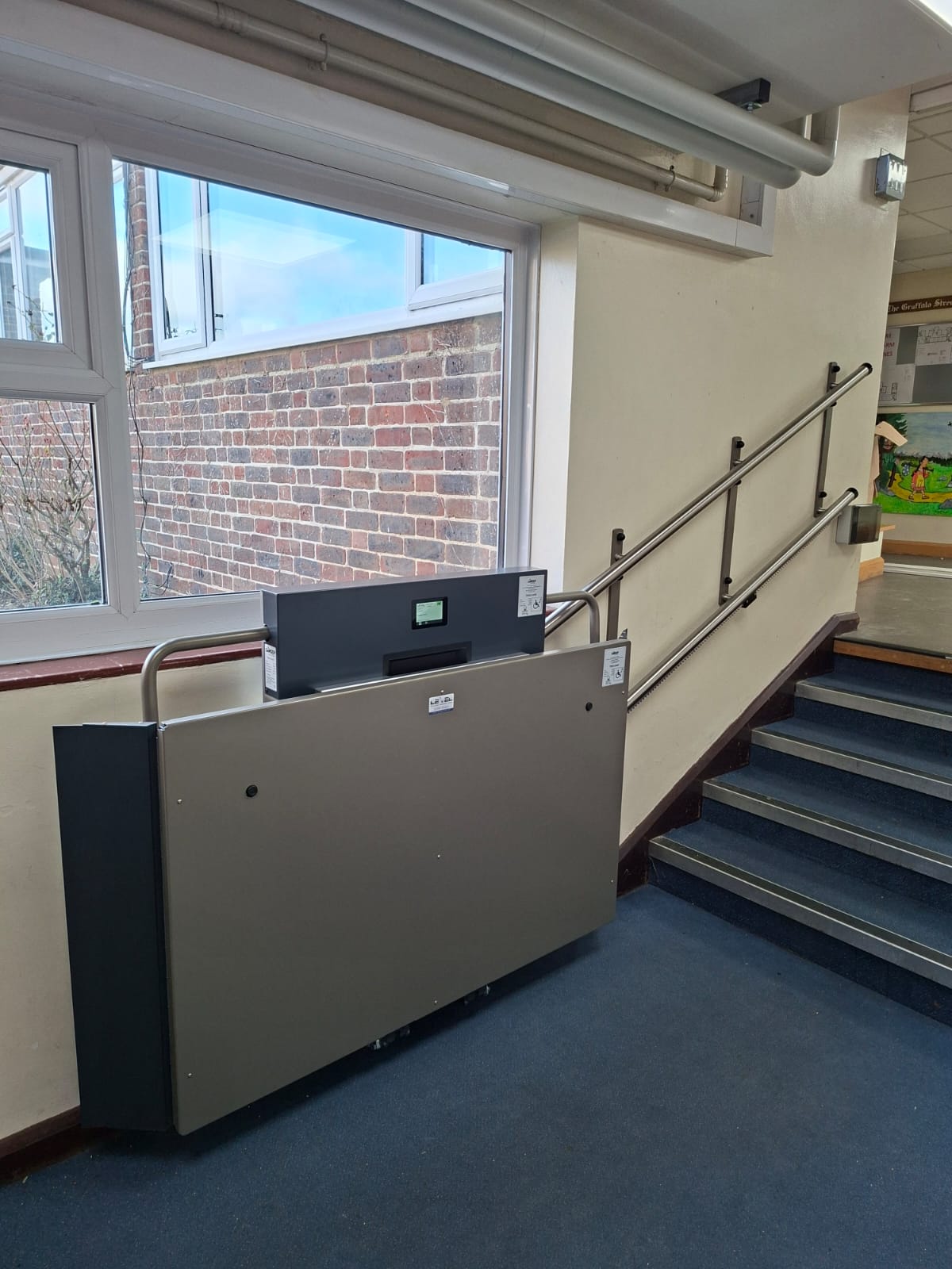 Side view of GTLE platform stair lift installed beside internal staircase at Laurel Lane Primary School