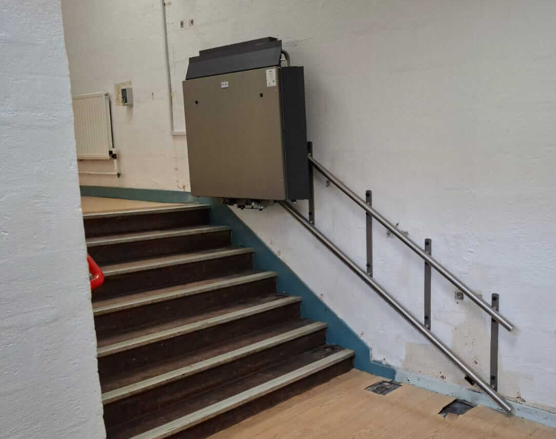 GTLE platform stair lift in folded parked position at upper landing, Saltash Community School.