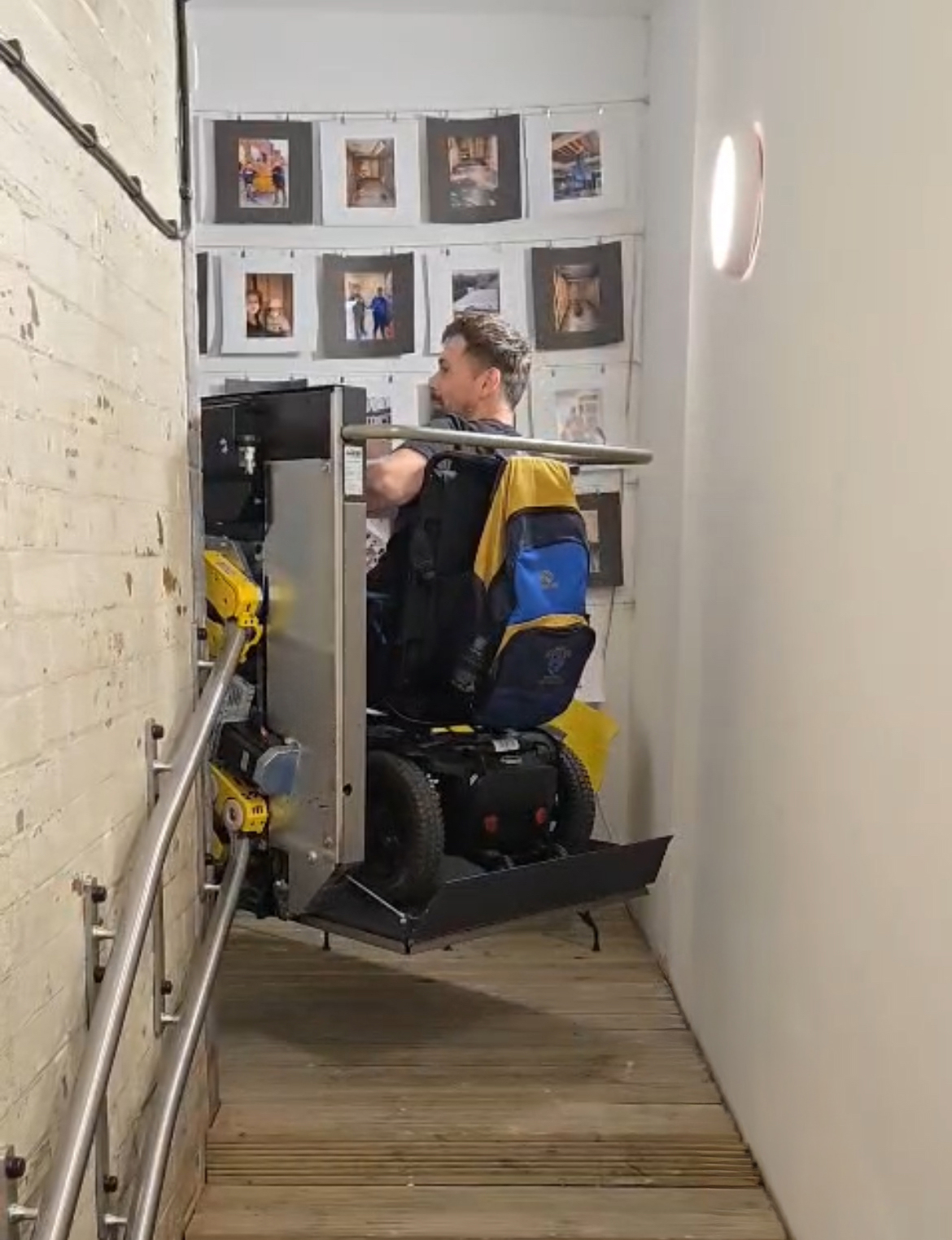Wheelchair user going round a tight bend in the stairs on a platform stair lift