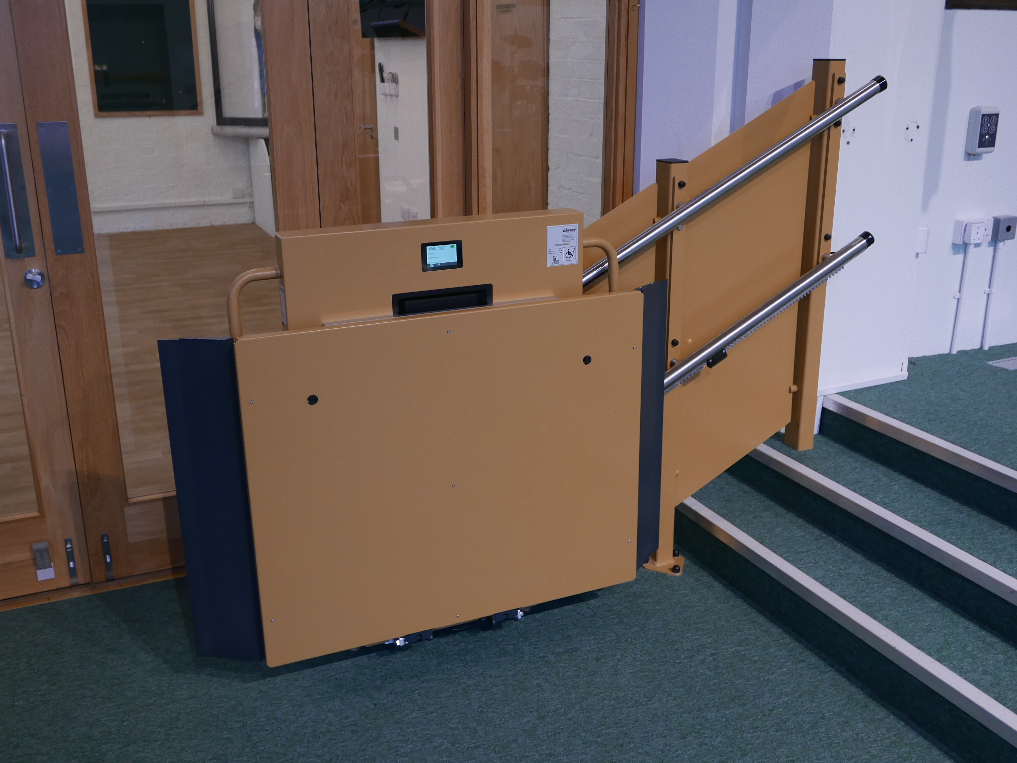 GTLE inclined stairlift shown in fully folded, stowed position at St Oswald's Church, demonstrating its compact footprint when not in use