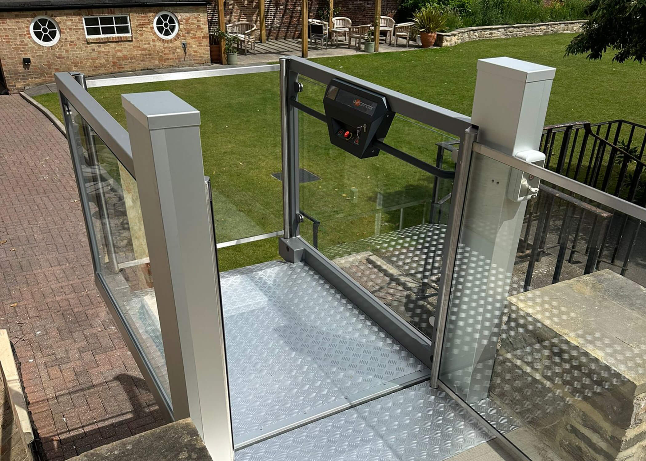 UnaPorte open-style platform lift raised to upper level in the garden at St Chad's College.