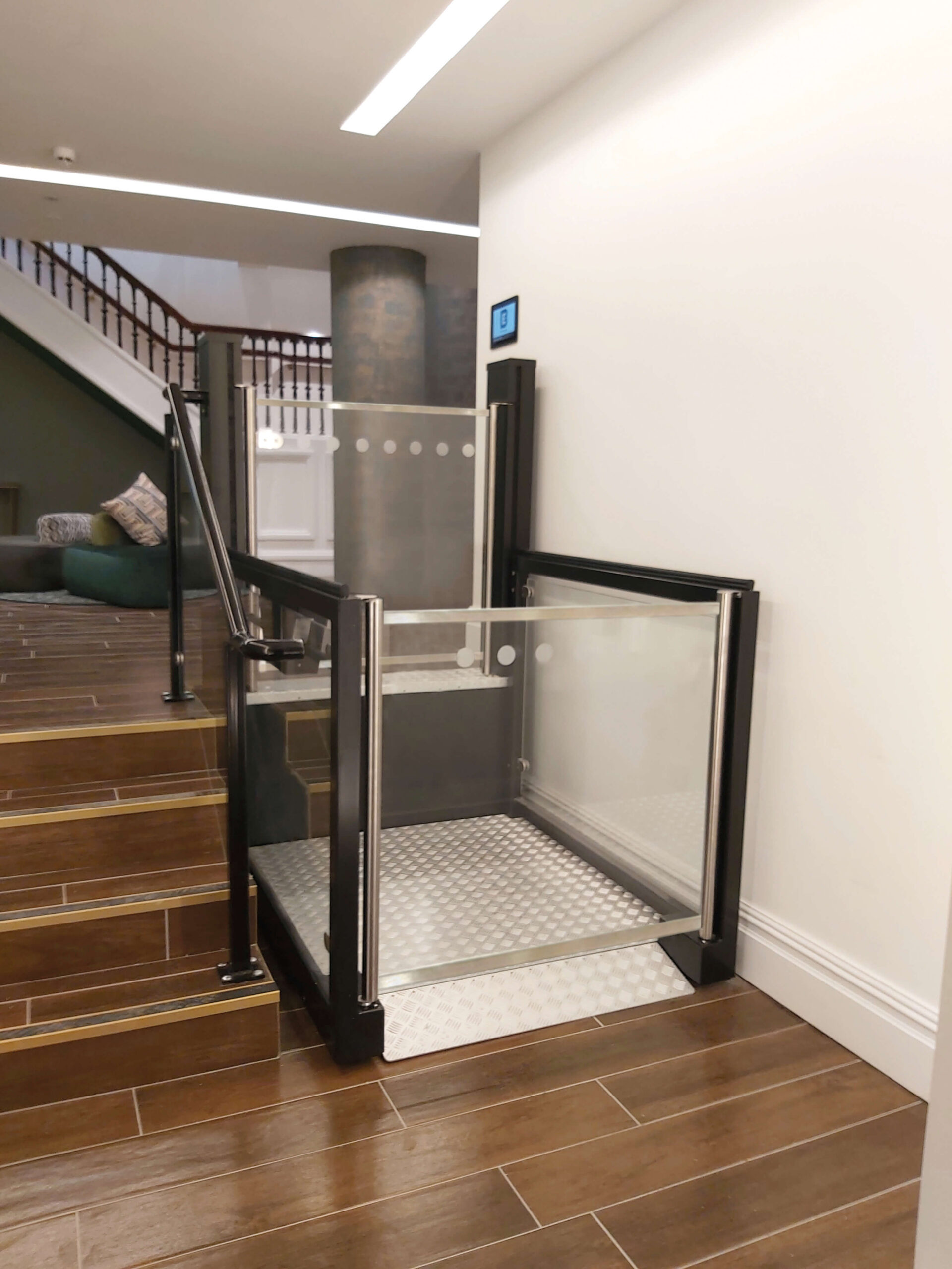 Low rise platform lift next to steps inside a building