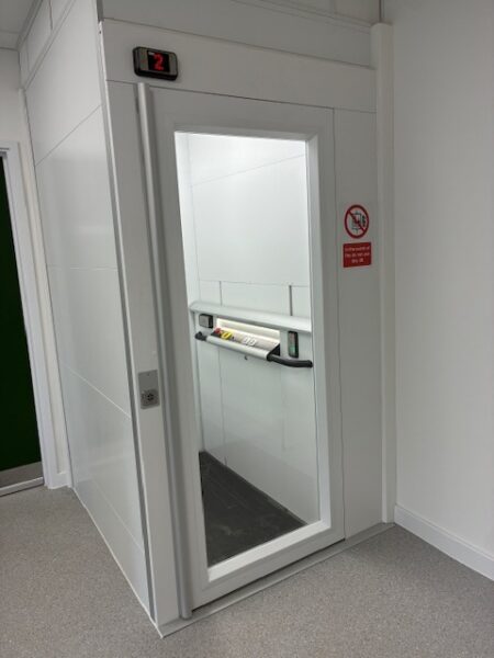 Vertical platform lift installed in a white-walled corridor at The Food Museum, East Anglia